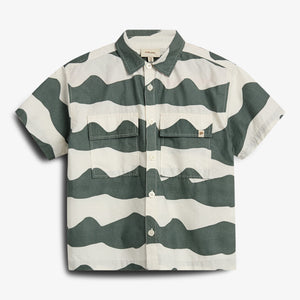 A short-sleeve button-up shirt features a wavy green and white pattern. It has two chest pockets and a label reading "MINI A TURE" inside the collar.