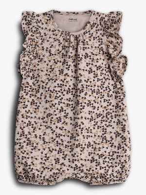 A floral-patterned baby romper with ruffled sleeves is displayed against a plain background. The text inside reads, "Pomp de Lux ORGANIC COTTON."