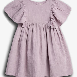 A lilac-colored, short-sleeved dress hangs against a plain white background, featuring a textured fabric with small embroidered patterns and a gathered, flowing skirt.