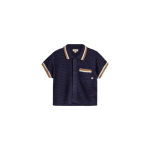A navy blue knitted short-sleeve shirt with button closure is presented on a plain background. It features a textured pattern, pocket with beige accents, and a label reading "puma kids."
