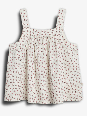 Sleeveless, floral-patterned dress with thick straps hangs against a plain backdrop. The fabric is light-colored with small, red floral designs scattered throughout.