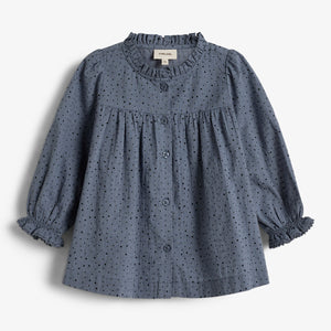 Blue polka dot blouse with buttons and ruffled collar and cuffs, on a plain white background. A small tag reads "pimelove 36M" inside the collar.