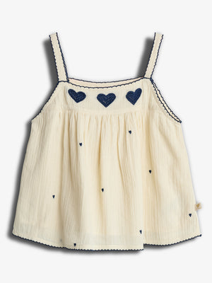 Cream-colored tank top adorned with dark blue heart embroidery and scalloped trim, hanging flat against a plain white background.