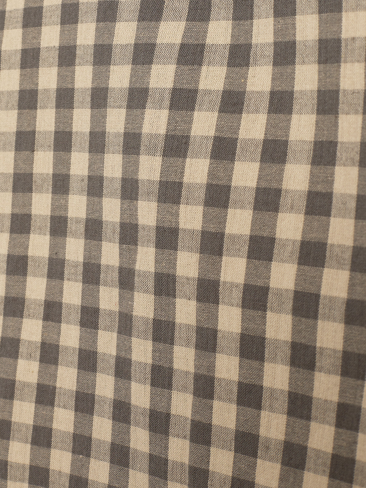 Ein Stoffmuster zeigt ein beige-schwarzes Karomuster in gleichmäßigen Quadraten. Es gibt keine weiteren Gegenstände oder Hintergründe sichtbar.