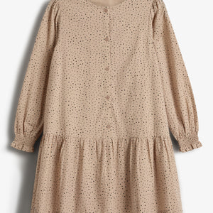 A tan, long-sleeved dress with black polka dots is neatly displayed. It features buttons down the front and a gathered hem, hanging against a plain white background.