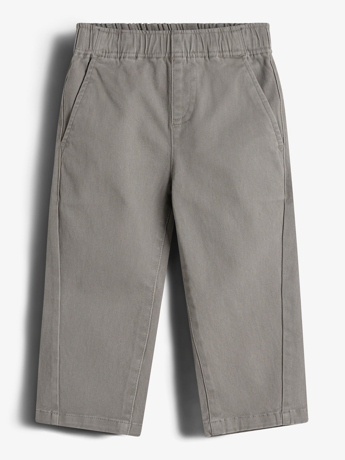 Graue Kinderhose liegt flach, mit zwei Seitentaschen und elastischem Bund. Die Hose hat einen einfachen, klassischen Schnitt und ist auf einem neutralen, glatten Hintergrund platziert.