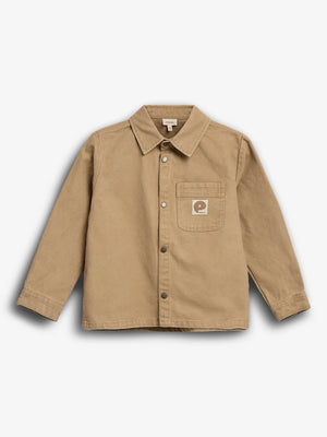 Tan jacket with a collar and buttoned front is displayed on a white background. A small chest pocket on the left features a square patch with a stylized "P" and the word "Patagonia".