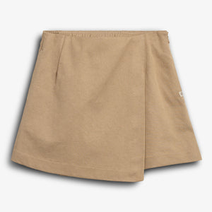 The object is a beige, A-line skirt with a wrap-over front design, lying flat. It features an elastic waistband and a small side tag. The background is plain white.