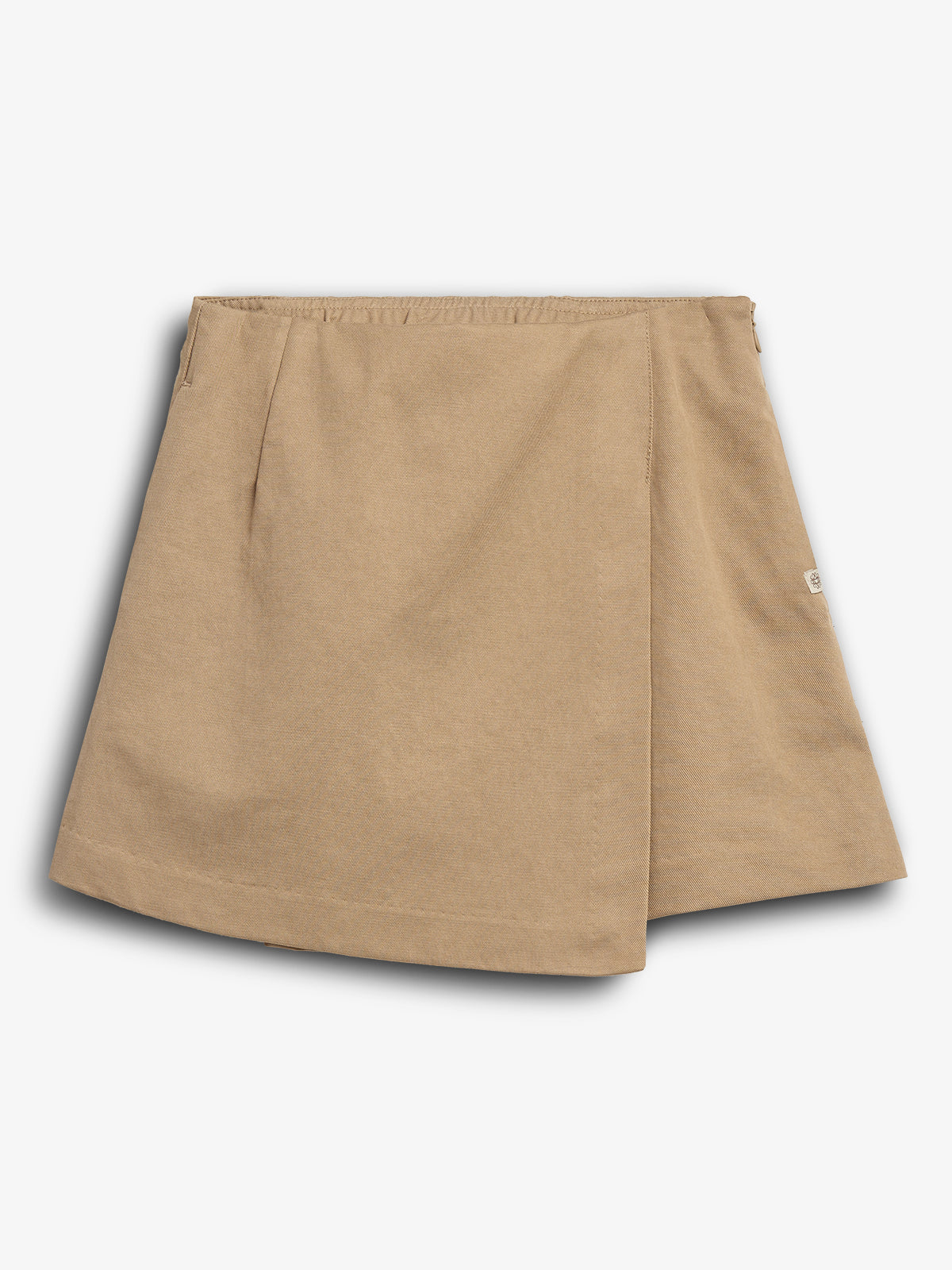 The object is a beige, A-line skirt with a wrap-over front design, lying flat. It features an elastic waistband and a small side tag. The background is plain white.