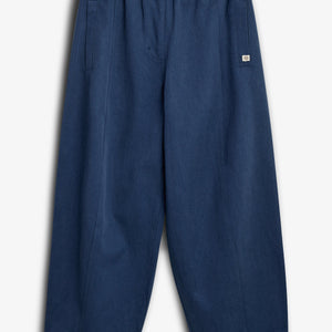 Blue pants with an elastic waistband and drawstring are laid flat on a white background. They feature side pockets and a small square logo on the right hip.