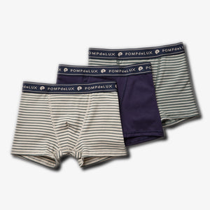 Three pairs of children’s boxer shorts are arranged. The first and third pairs have horizontal stripes, while the second is solid navy. All feature "POMPdeLUX" printed on the waistband, placed on a plain white background.