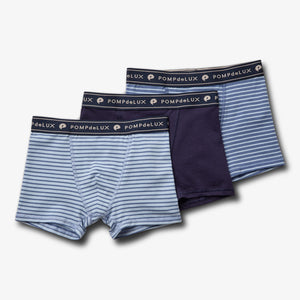 Three pairs of boys' underwear are displayed: two with light and dark blue stripes, one solid navy, labeled "POMPdeLUX" on the waistband, against a plain white background.