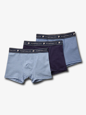 Three pairs of boys' underwear are displayed: two with light and dark blue stripes, one solid navy, labeled "POMPdeLUX" on the waistband, against a plain white background.