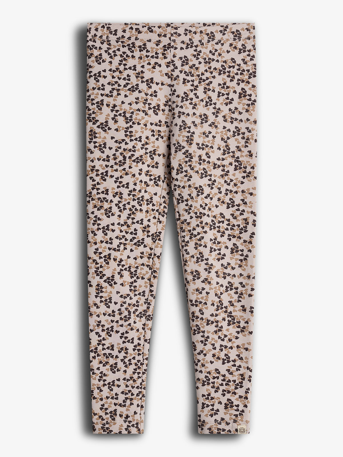 Leggings are lying flat, featuring a pattern of small, scattered brown and black floral designs against a light beige background. The context is a plain, white surface.
