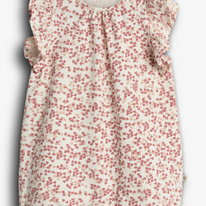 A white baby romper decorated with a pink strawberry pattern, featuring ruffled sleeves. The label reads "PURE.LUX ORGANIC COTTON," suggesting an emphasis on organic materials.