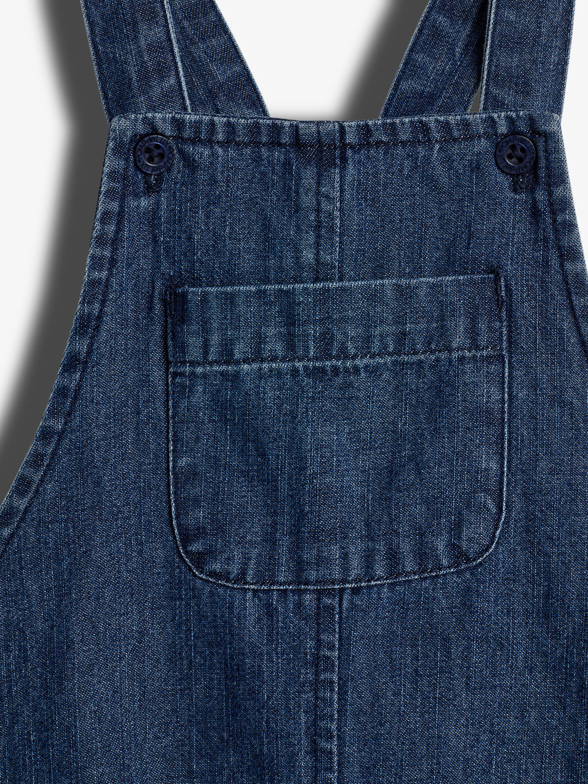 Denim bib overalls with a front pocket and two buttons on straps, displayed against a plain background.