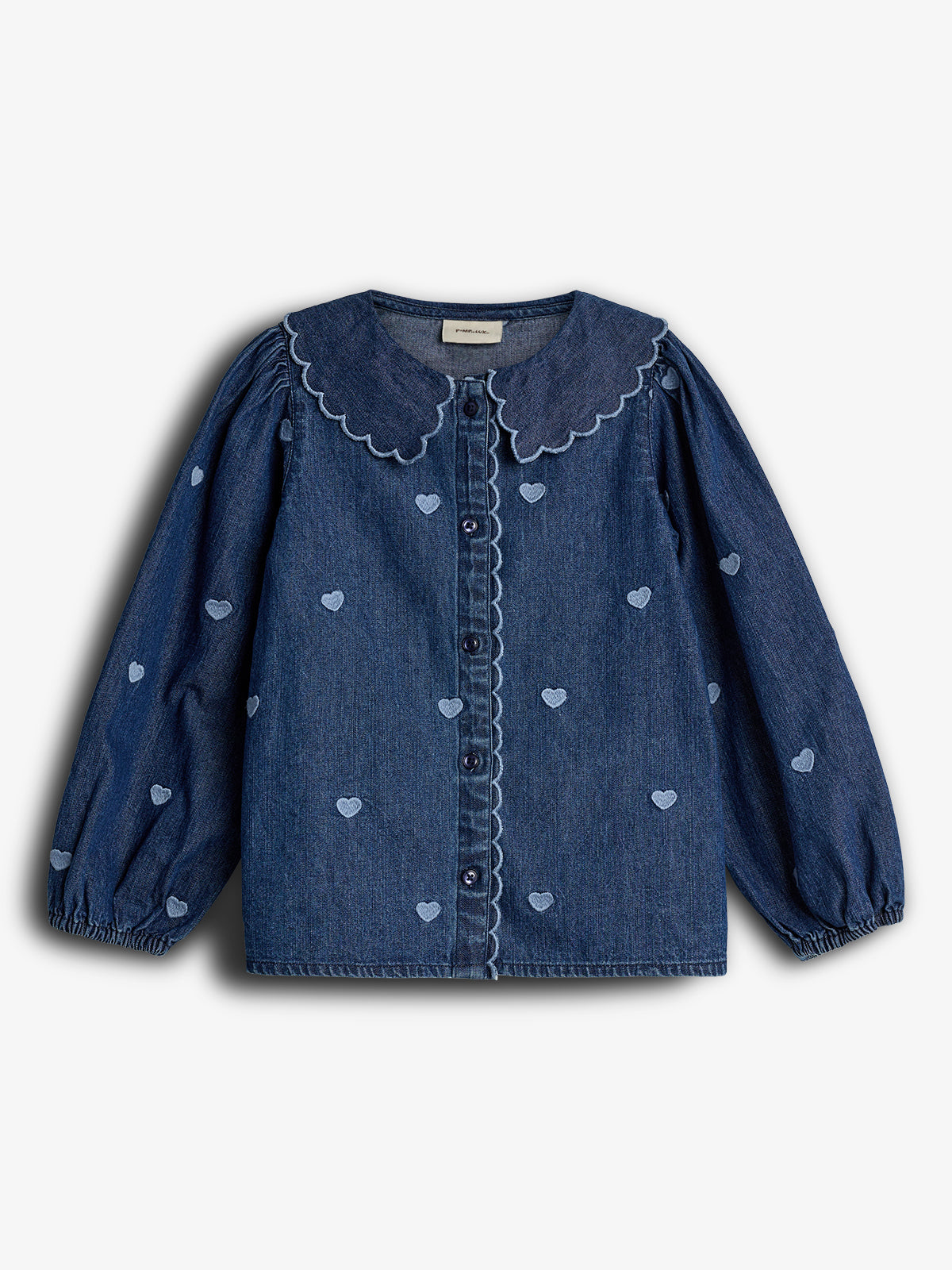 A denim blouse with long sleeves features embroidered hearts and a scalloped collar. It has buttons down the front and is set against a plain white background.