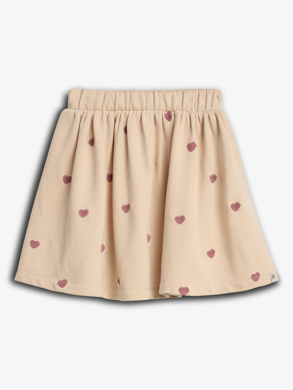 The skirt has an elastic waistband with a light beige color patterned with small, pink heart designs, against a plain white background.