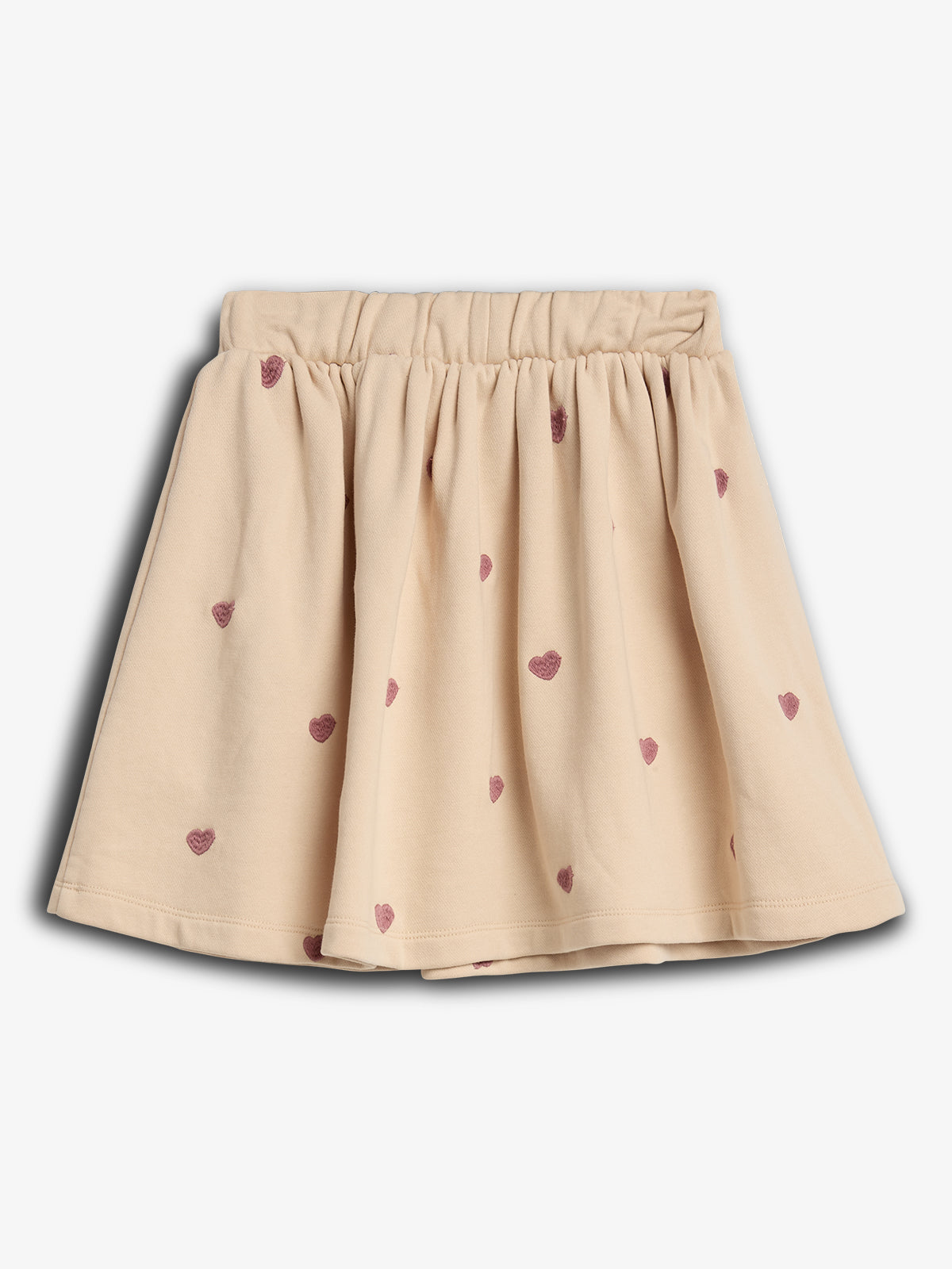 A cream-colored, pleated skirt decorated with small, red heart patterns is displayed on a plain white background.