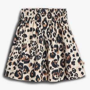 A skirt displays a leopard print pattern with black and brown spots on a beige background, featuring a gathered waistband. The background is plain white.