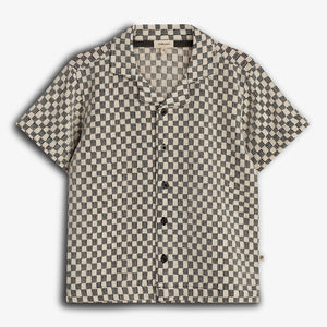 Short-sleeved shirt with a black and white checkered pattern, featuring black buttons and a collar, displayed against a plain white background.