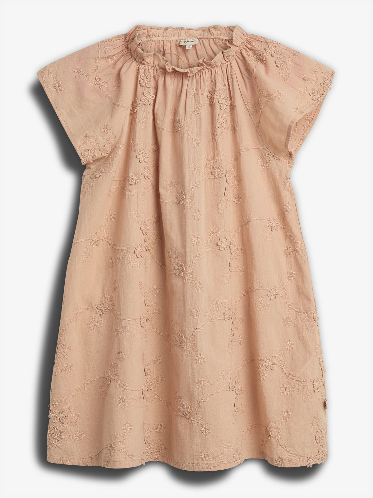 A peach-colored floral dress with short sleeves hangs against a plain backdrop. The fabric displays delicate embroidered flowers, and the neckline is slightly gathered for a ruffled effect.