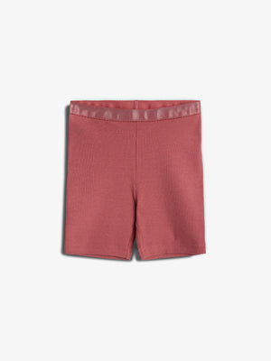 Red knit shorts are laid flat on a white background, highlighting their texture and simple design. The ribbed fabric is visible, and the waistband appears elastic.