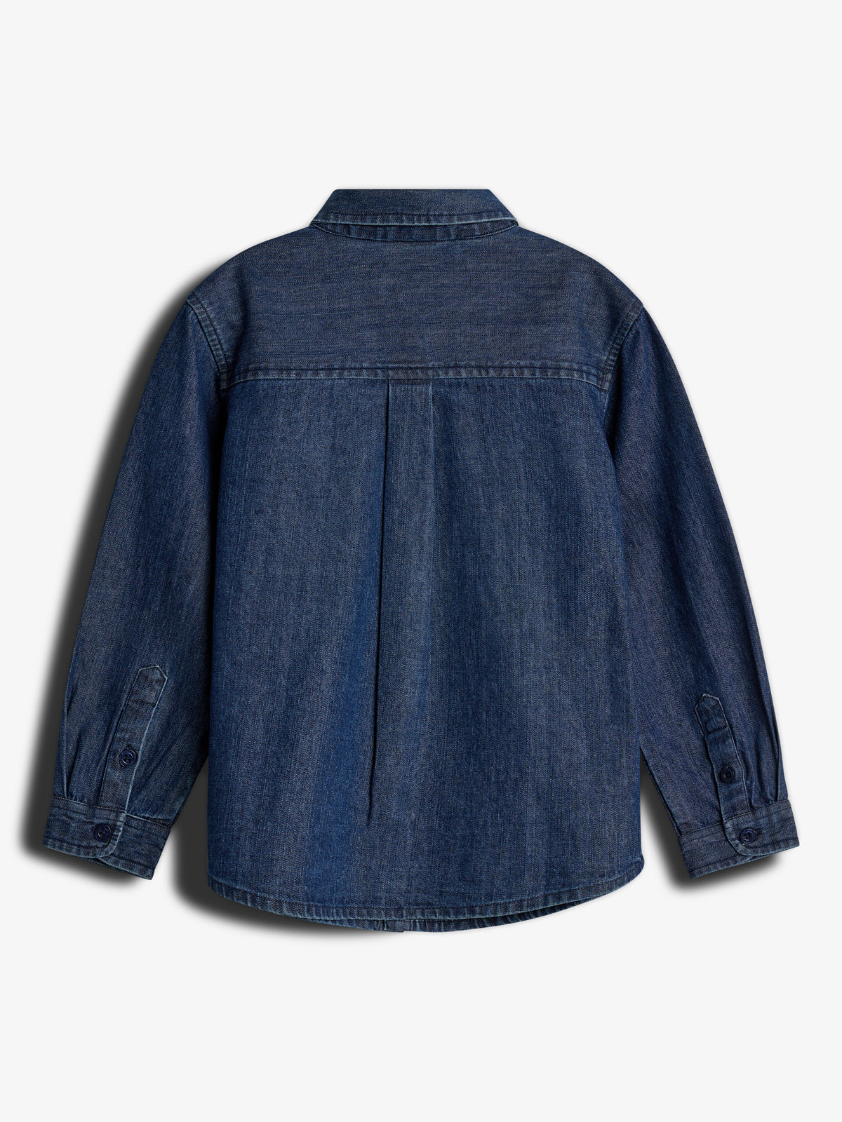 A denim shirt is displayed with long sleeves and buttoned cuffs, viewed from the back. It features a central pleat and a fold-down collar, set against a plain background.
