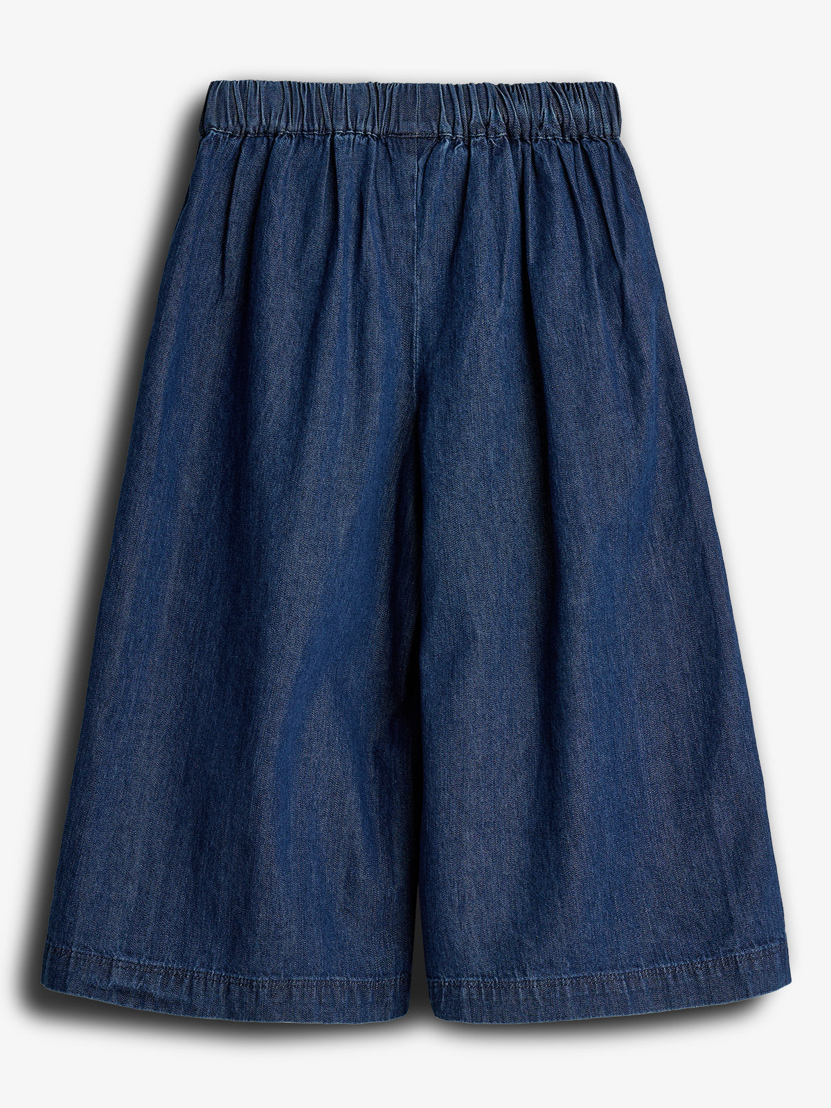 Dark blue denim culottes with an elastic waistband hang freely against a plain white background, displaying their wide-leg design and casual style.