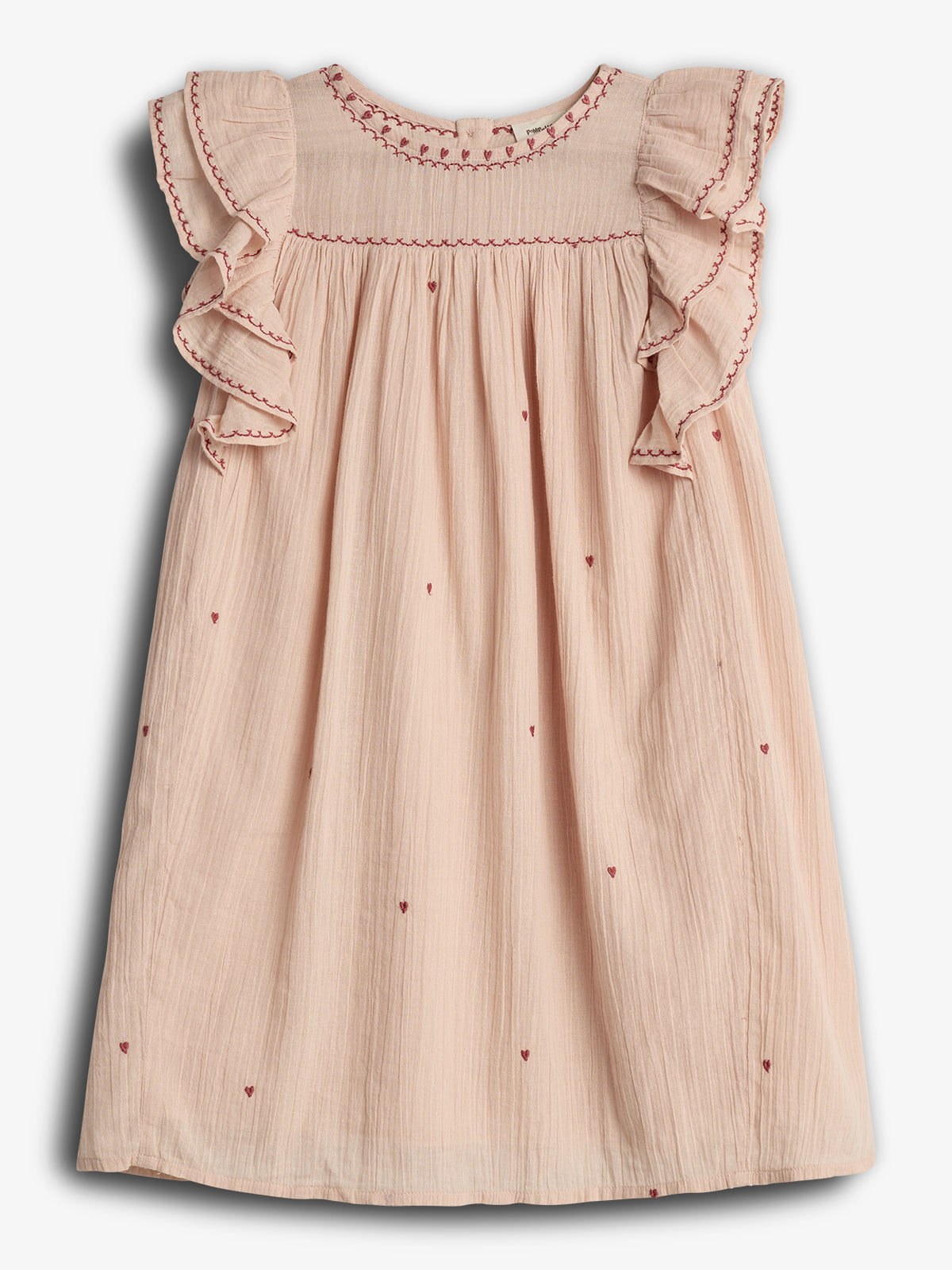 A pale pink sleeveless dress features ruffled shoulders, red stitching accents, and small heart patterns. It lies flat against a white background, showcasing its simple, delicate design.
