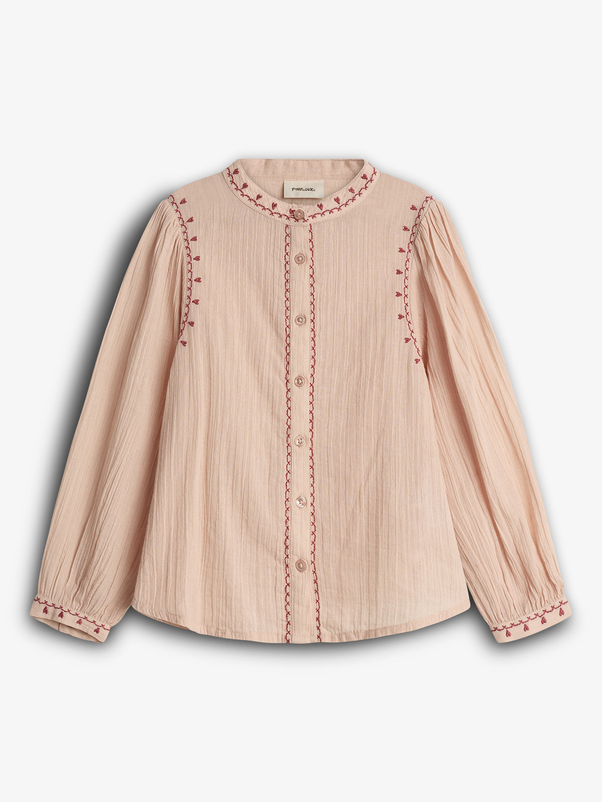 A beige long-sleeved blouse with red embroidered trim and buttons down the front, set against a plain white background.