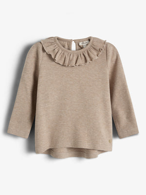 Ein beige Pullover mit langen Ärmeln und Rüschendetail am Hals hängt vor einem weißen Hintergrund. Ein kleines Metallemblem befindet sich am unteren Rand.