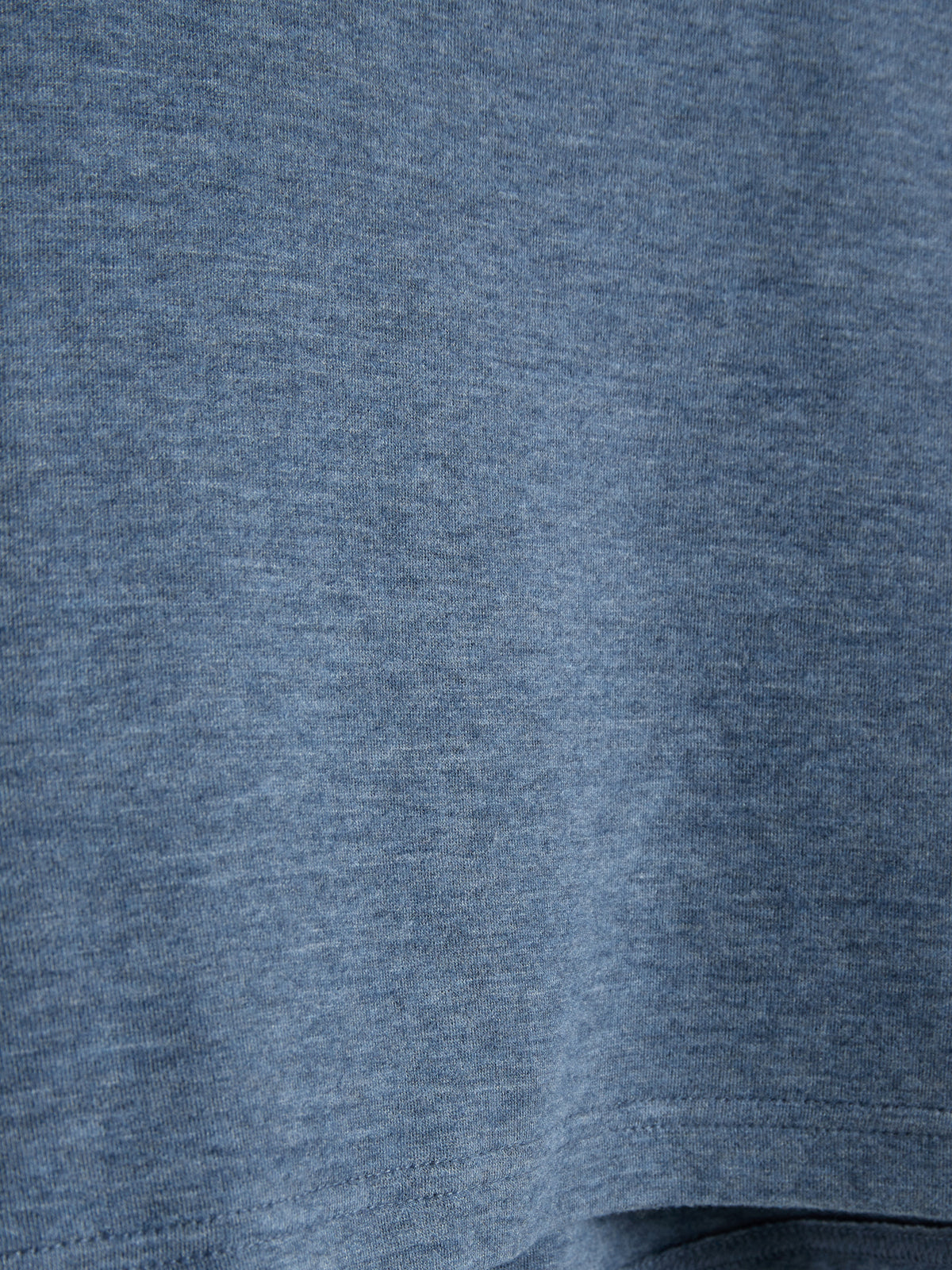 Ein blauer Stoff zeigt eine feine, gleichmäßige Textur ohne sichtbare Muster oder Designs. Der Fokus liegt auf der Materialbeschaffenheit in einer ruhigen, neutralen Umgebung. Kein Text vorhanden.