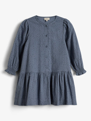 A blue, long-sleeved dress features small perforated holes and buttons down the front, with a gathered skirt. It hangs against a plain white background.