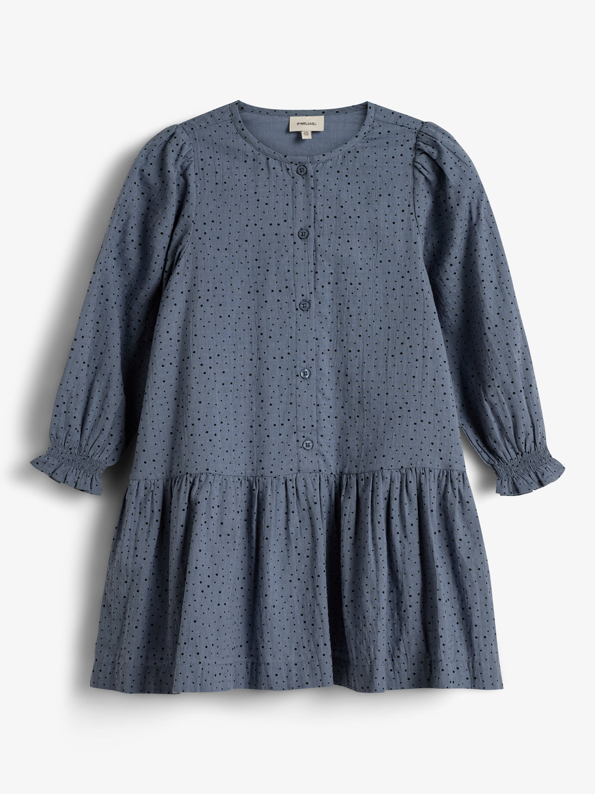 A blue, long-sleeved dress features small perforated holes and buttons down the front, with a gathered skirt. It hangs against a plain white background.
