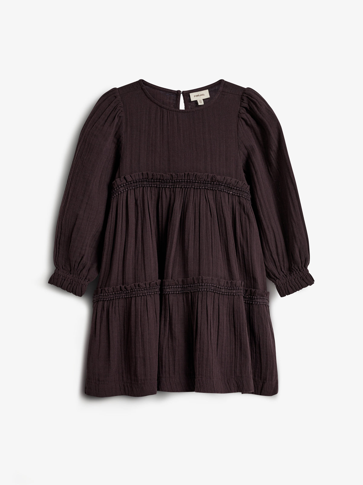 Ein dunkelbraunes Kleid mit langen Ärmeln hängt vor weißem Hintergrund. Es hat gesmokte Details auf der Brust und Taille. Das Etikett zeigt den Markennamen "peüt-itbö".