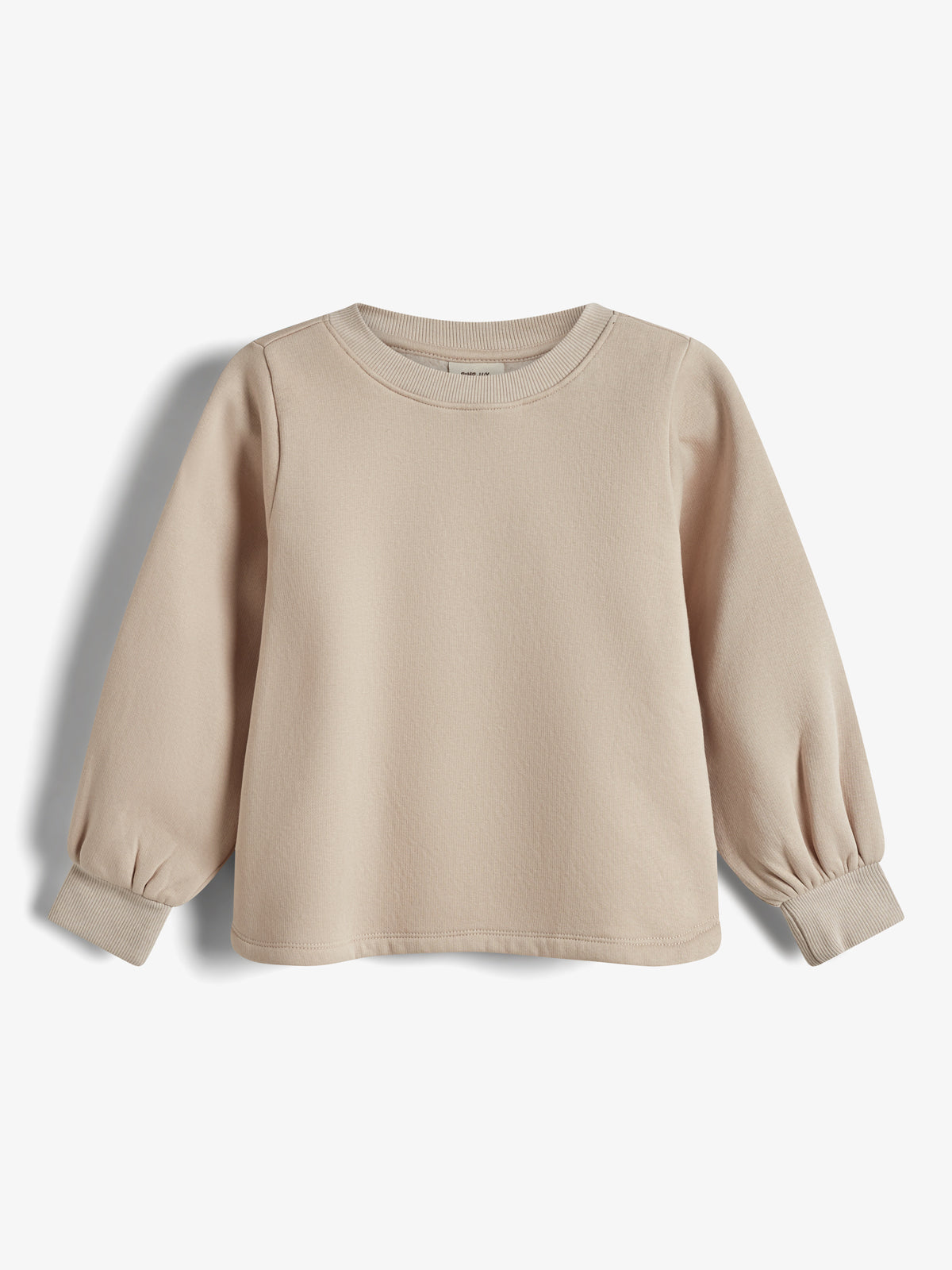 Beiger Pullover liegt flach auf weißem Hintergrund. Lange Ärmel mit Bündchen und ein Rundhalsausschnitt definieren das Kleidungsstück. Einfaches, ungemustertes Design ohne sichtbaren Text oder Aufdruck.