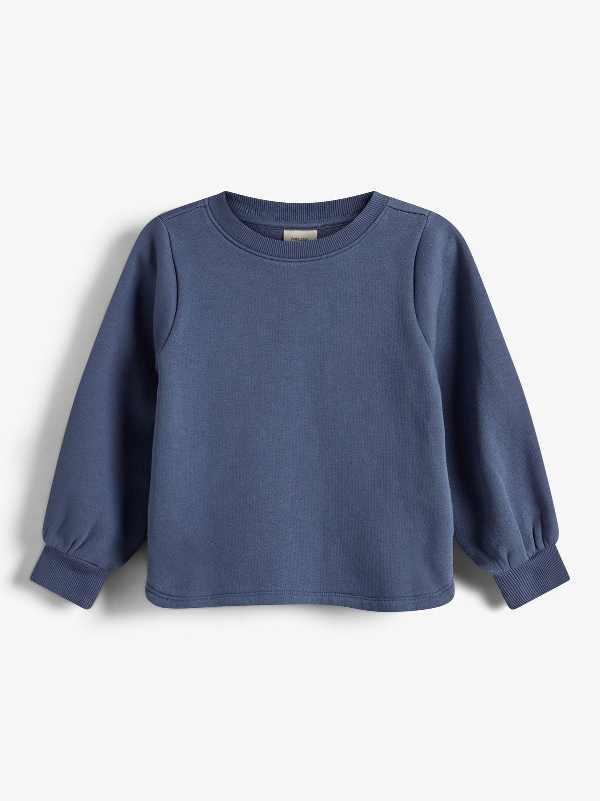 Ein schlichtes, blaues Sweatshirt mit langen Ärmeln hängt vor einem weißen Hintergrund. Die Bündchen sind gerippt, und der Stoff wirkt weich und gemütlich.