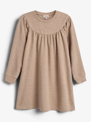 Ein beige Kinderkleid mit langen Ärmeln, Rundhalsausschnitt und gerafftem Brustbereich, hängt vor einem weißen Hintergrund. Im Nackenetikett steht "smile_love".