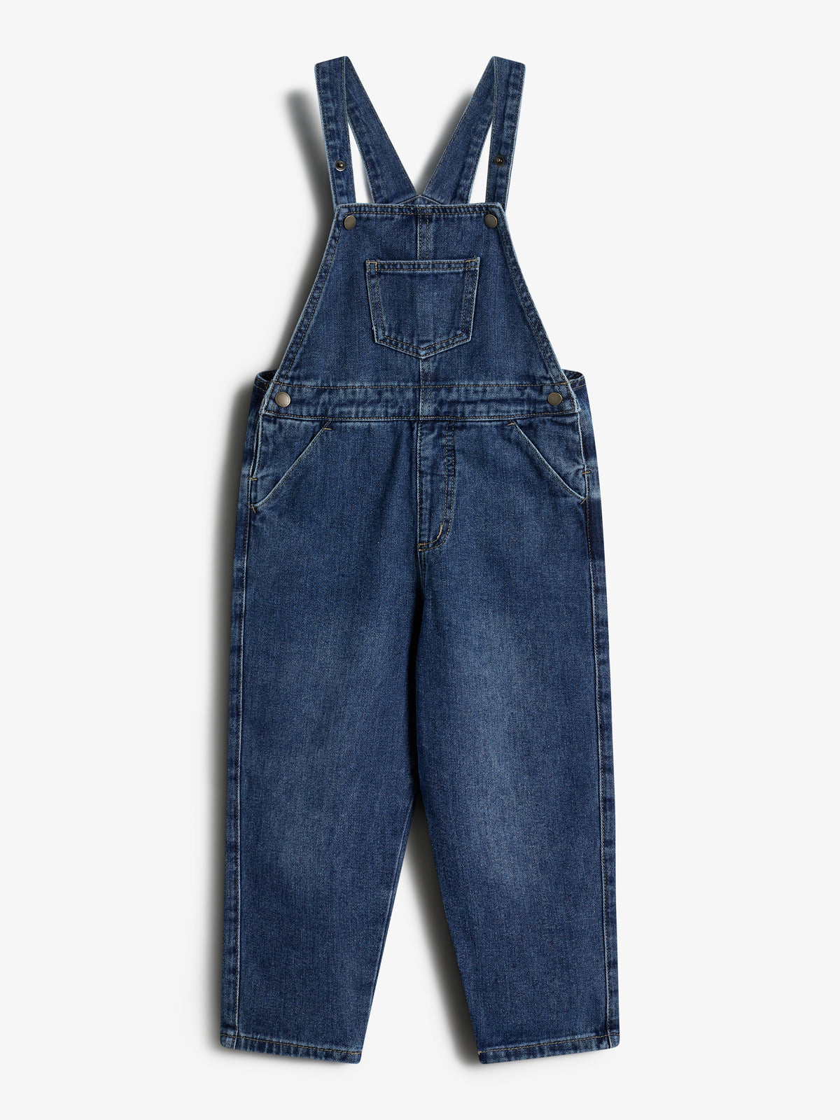Eine blaue Jeans-Latzhose mit Hosenträgern liegt flach auf einem weißen Hintergrund. Sie hat eine Brusttasche und seitliche Taschen.