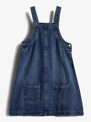 Jeanskleid mit Trägern und zwei Vordertaschen liegt flach auf weißem Hintergrund. Nieten an den Trägern verleihen dem Kleid Struktur. Kontextlos präsentiert, ohne sichtbare Umgebung.