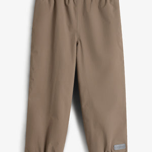 Beige Kinderhose liegt flach mit elastischen Bündchen am oberen und unteren Rand. Im rechten unteren Bereich befindet sich ein kleines Etikett mit der Aufschrift: "FORMKIDS". Hintergrund ist neutral.