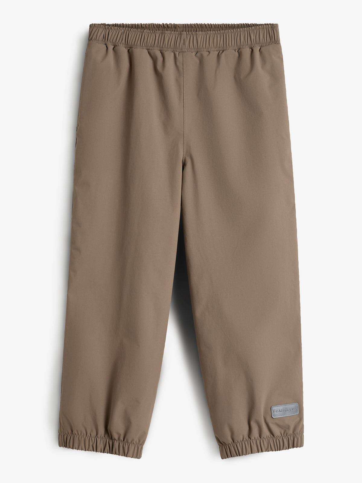 Beige Kinderhose liegt flach mit elastischen Bündchen am oberen und unteren Rand. Im rechten unteren Bereich befindet sich ein kleines Etikett mit der Aufschrift: "FORMKIDS". Hintergrund ist neutral.