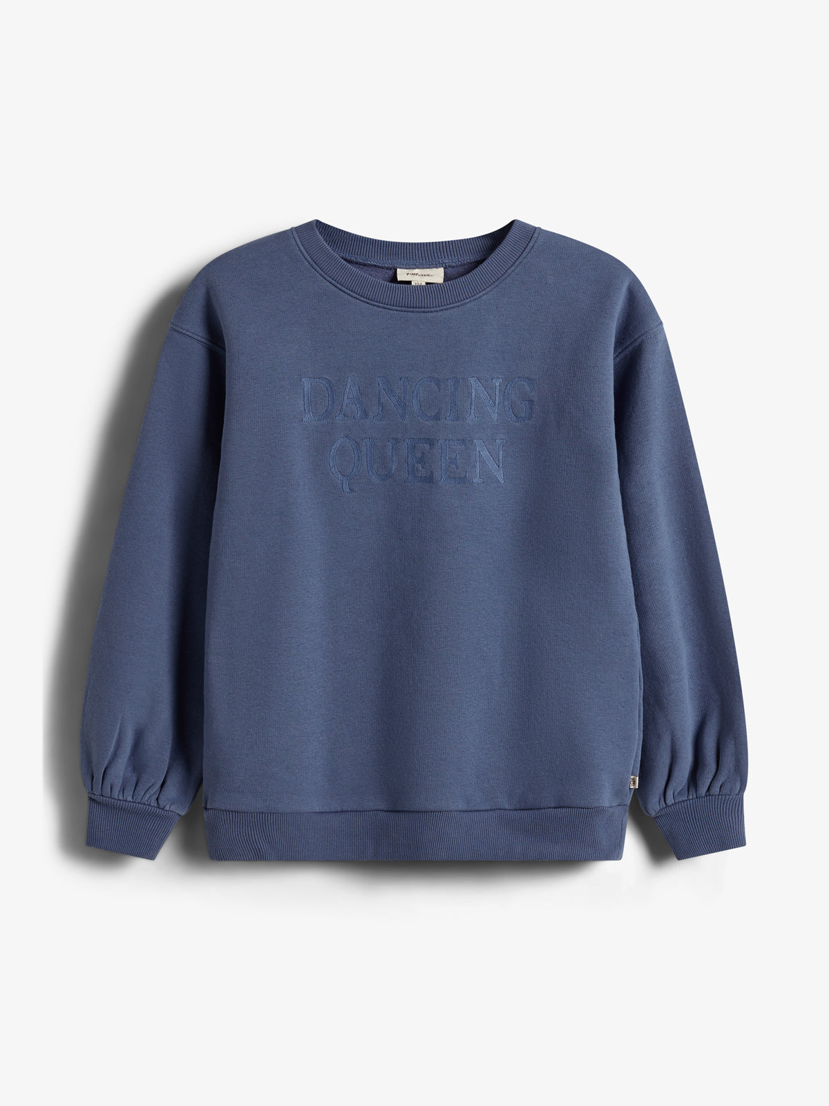 Blauer Pullover mit der gestickten Aufschrift "DANCING QUEEN" auf der Vorderseite, hängt vor einem neutralen, hellen Hintergrund.