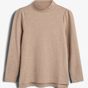 Beige long-sleeve turtleneck top hanging against a plain white background. The fabric appears soft, with a slight drape under the collar. A small metallic logo embellishes the lower edge.
