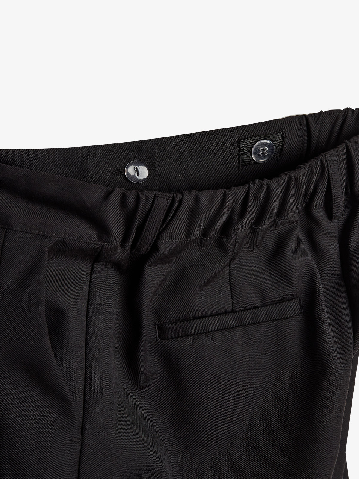 Black trousers with an elastic waistband and button fastening, featuring a back pocket. The fabric appears smooth, photographed against a plain white background.