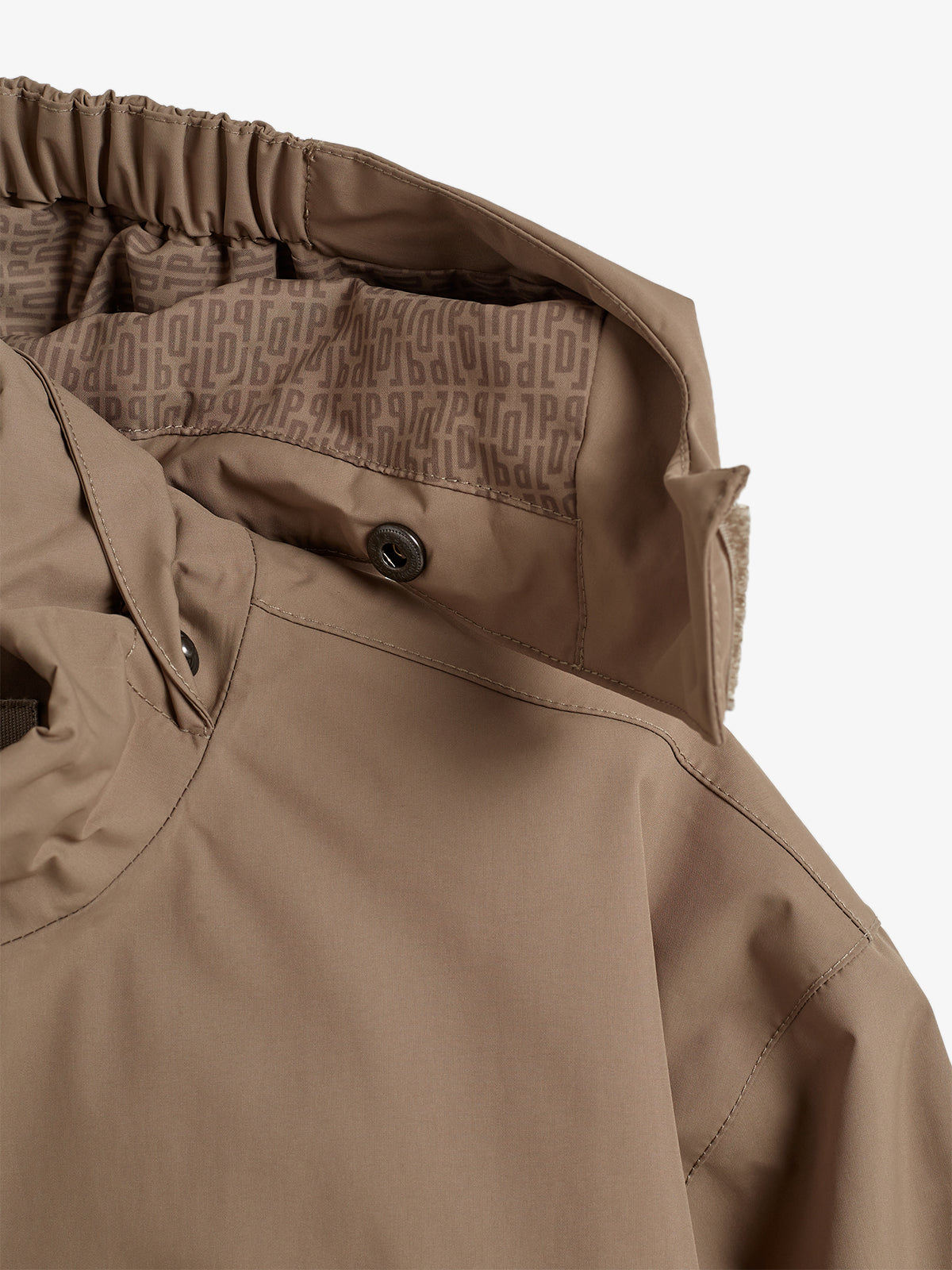 Braune Jacke zeigt Kapuze mit bedrucktem Innenfutter, angezogen mit elastischer Kordel. Umgebung ist ein neutraler, heller Hintergrund. Futter zeigt wiederholtes "P" Muster.