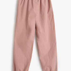 Eine rosa Hose liegt flach auf weißem Hintergrund. Sie hat elastische Bündchen an Taille und Knöcheln. Am unteren Rand ist der Text "POIVRE BLANC" zu sehen.